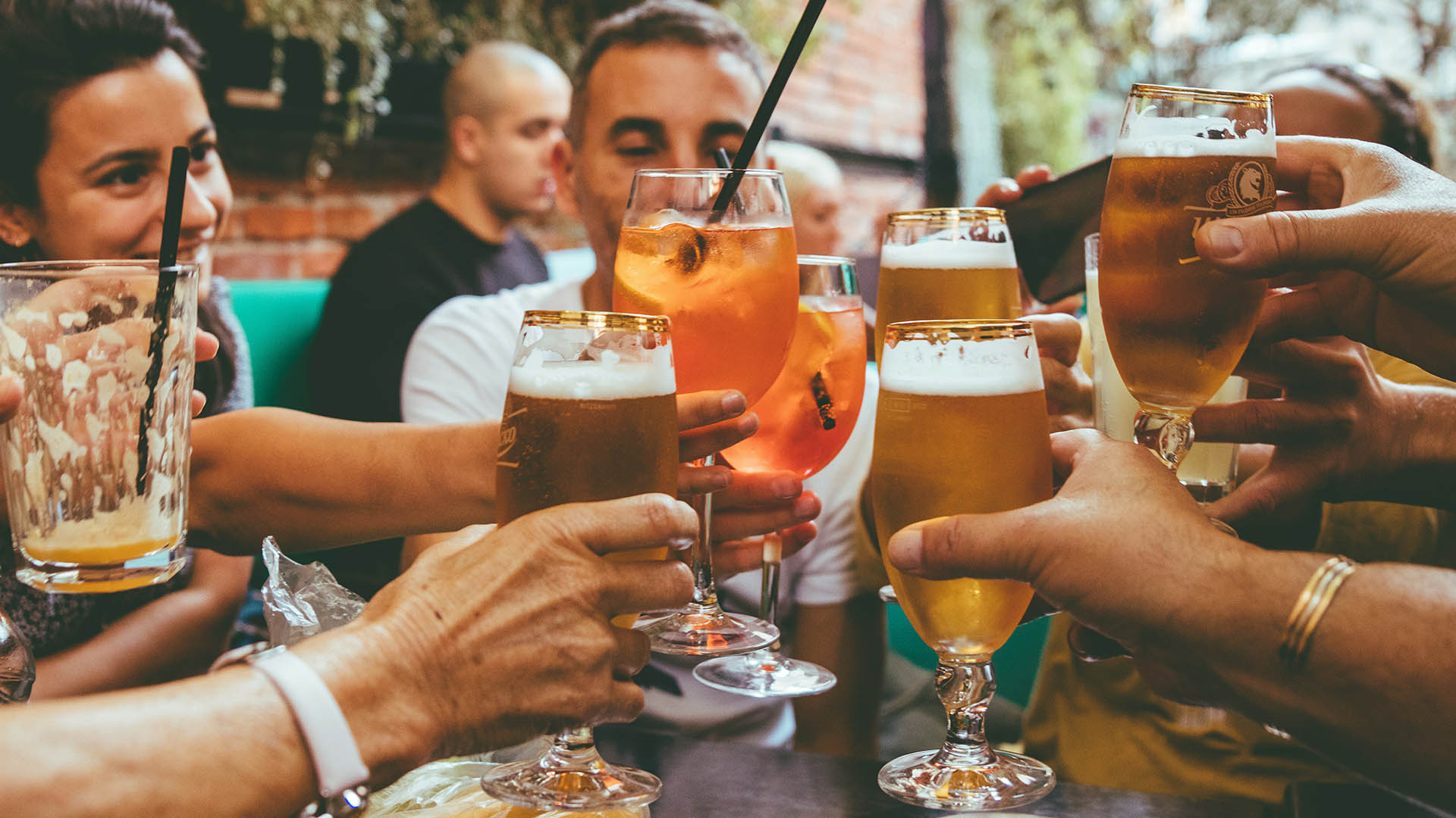 Friends toasting together with cocktails, wine and beer.