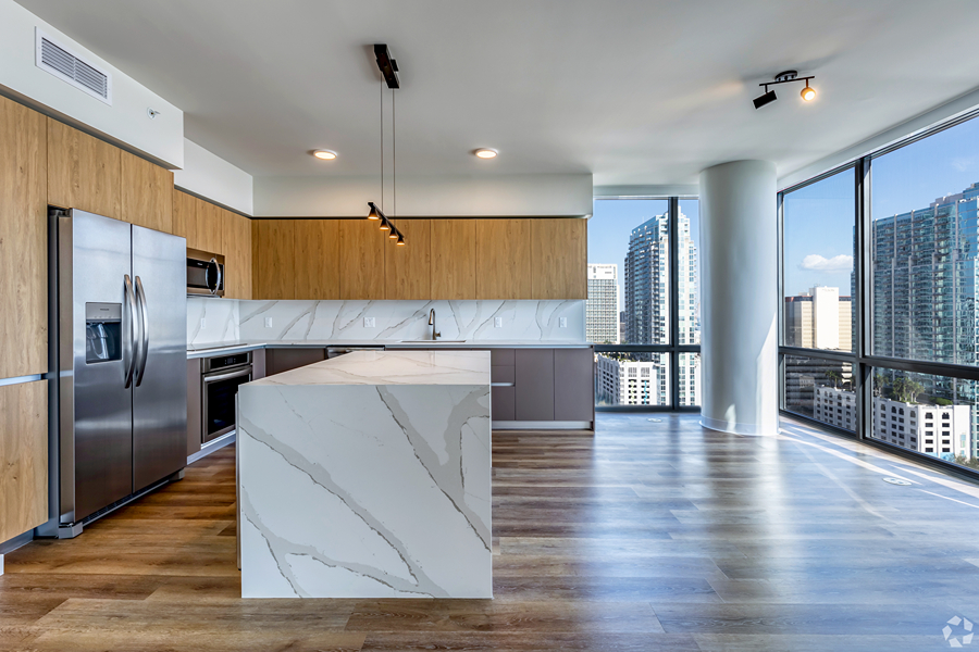 Aer apartment kitchen with modern finishes overlooking city.