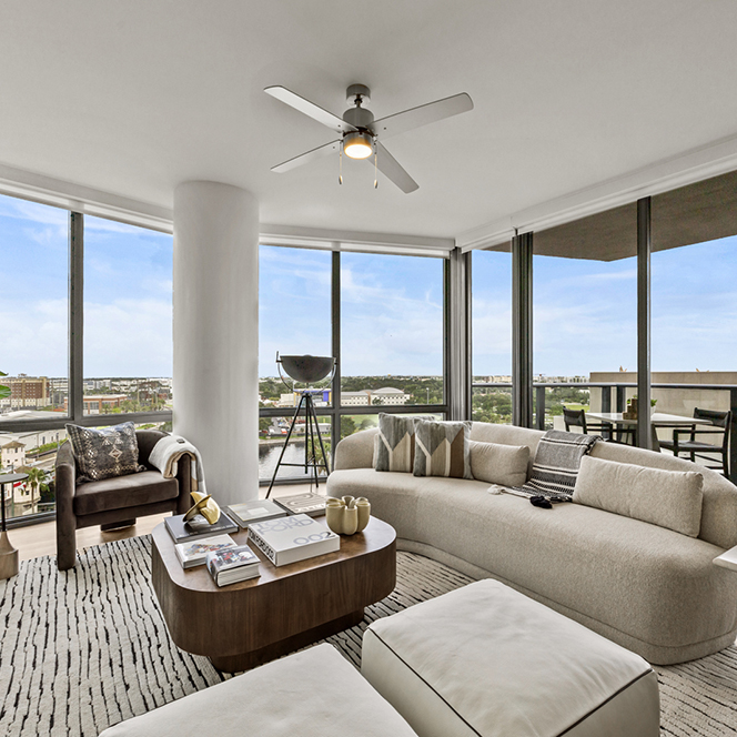 Aer apartment living room with plush furniture overlooking city.