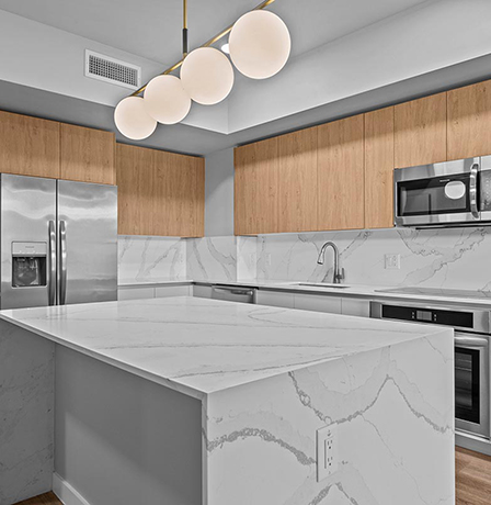 Aer apartment kitchen with elegant counters and stainless steel appliances.