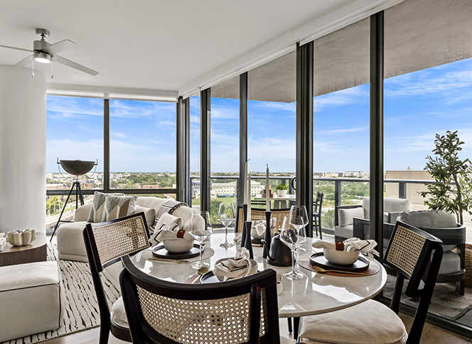 Aer apartment living area with plush seating and elegant dining table overlooking city.
