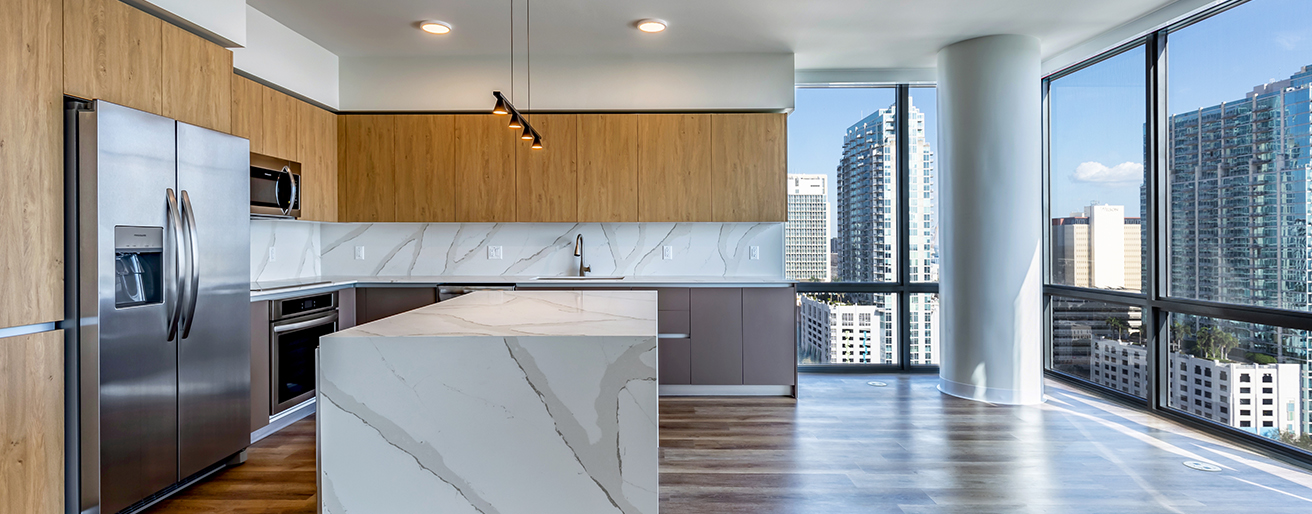 Aer apartment kitchen with modern finishes overlooking city.