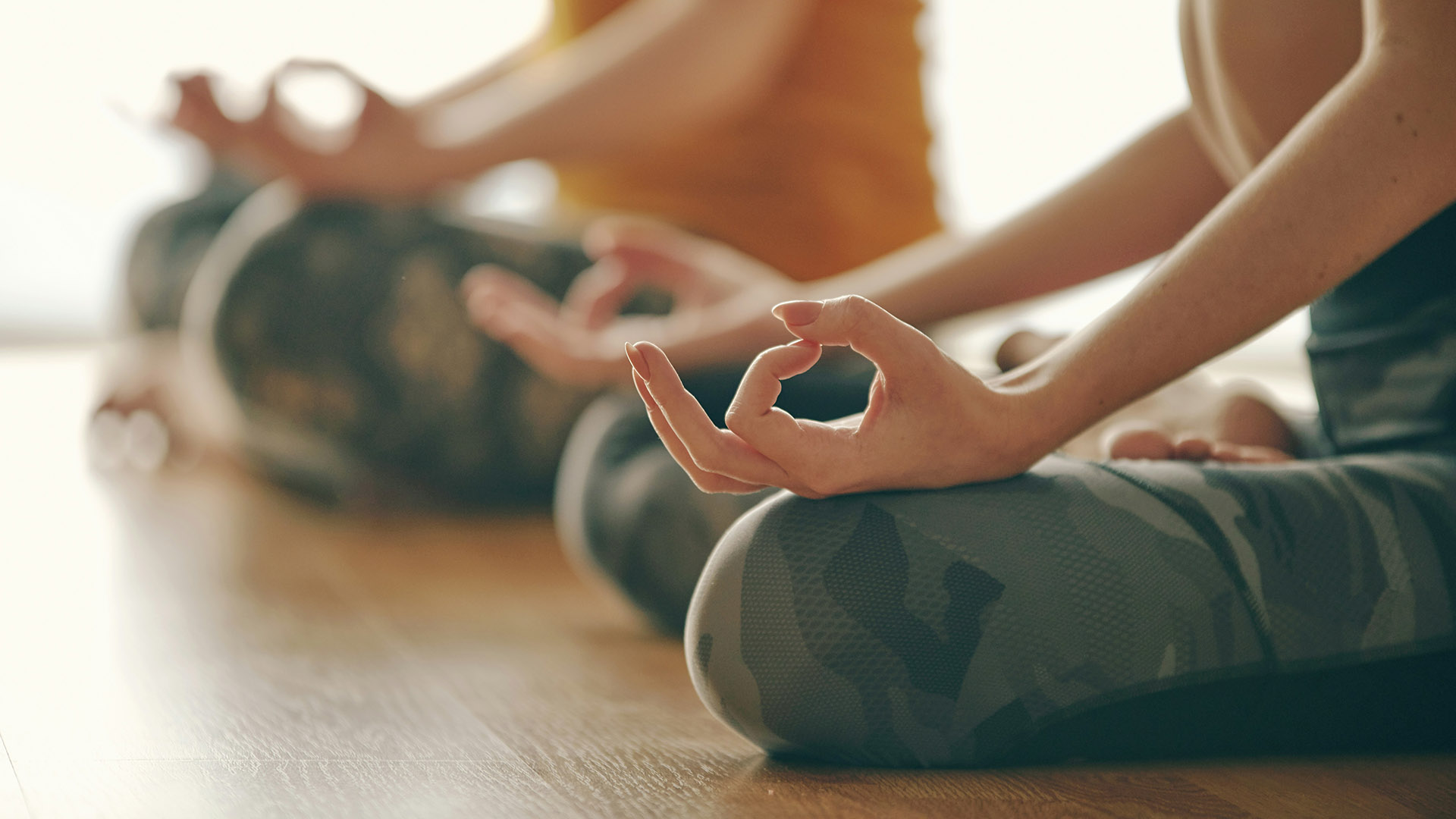 Two people seated in a yoga pose.